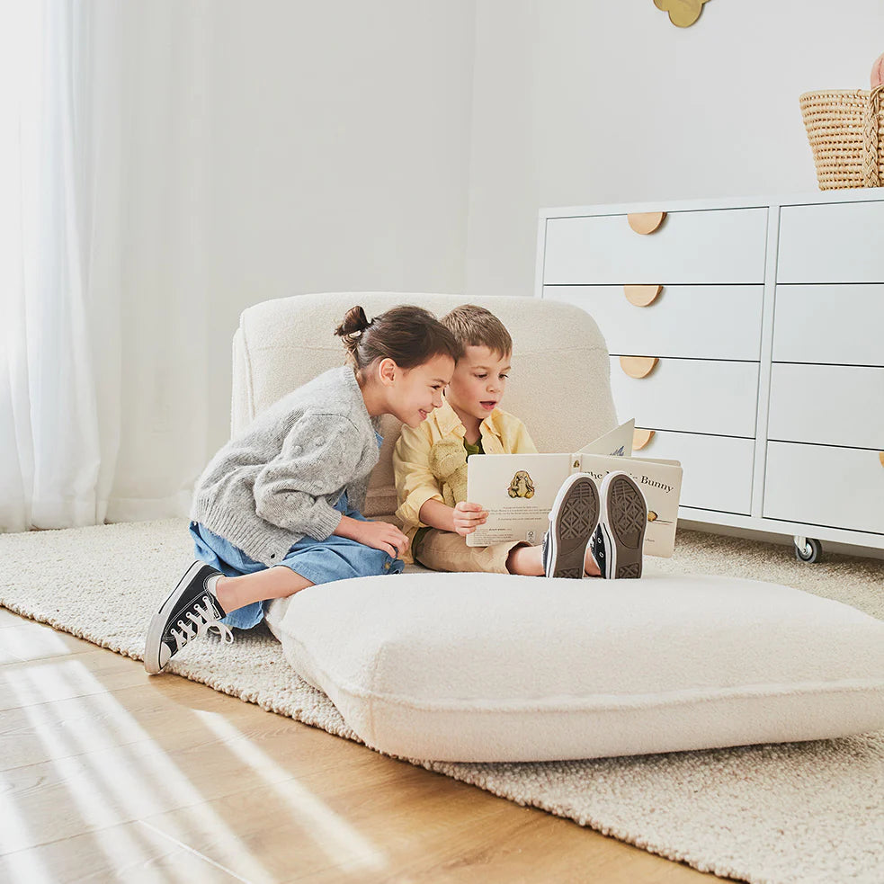 two kids playing on a fold out sofa bed